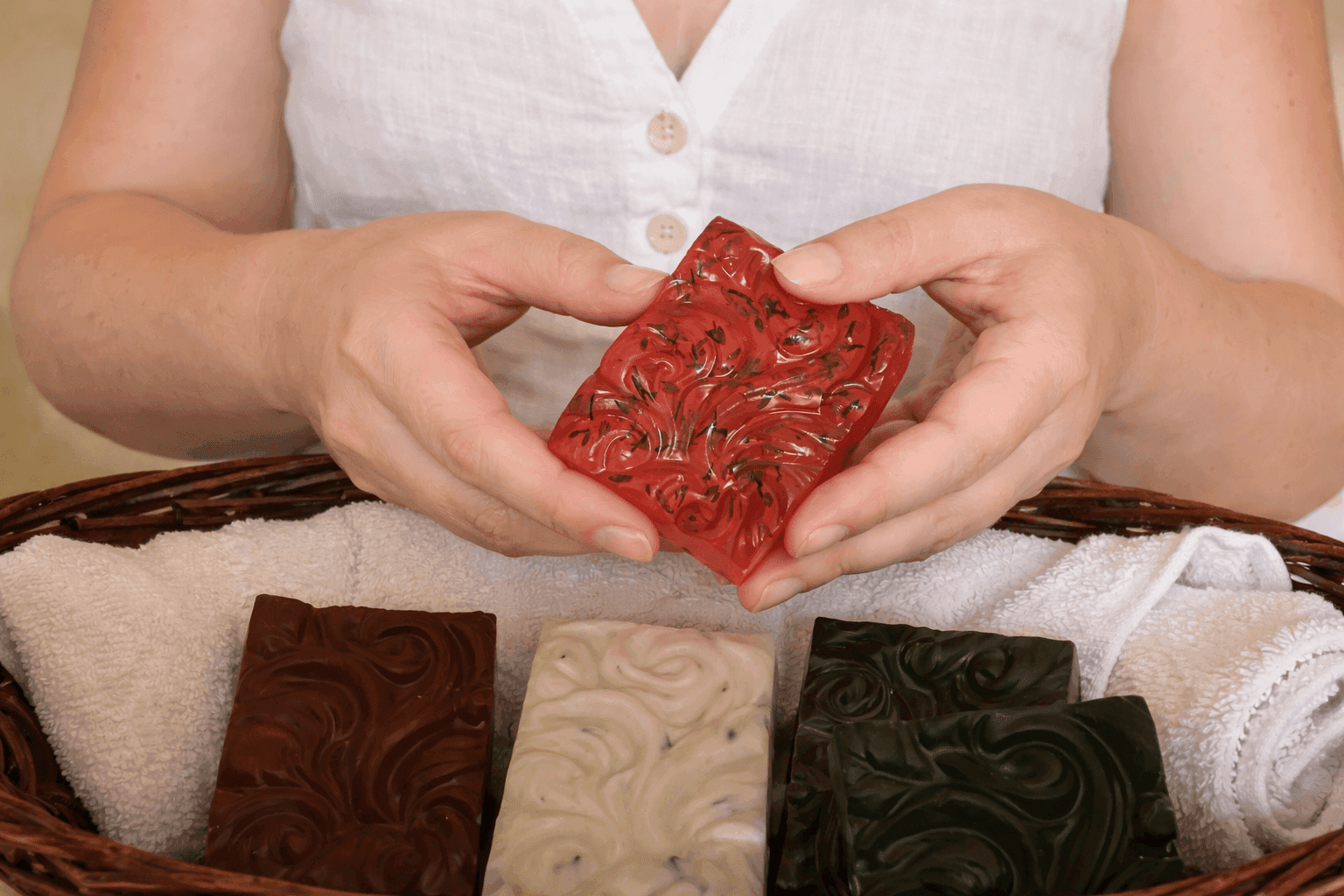 Manos preparando aceites botánicos sobre una mesa de madera